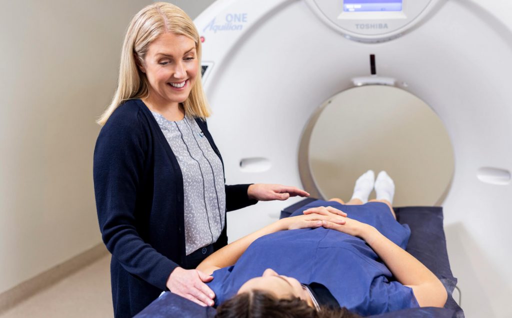 Radiographer preparing a patient for a CT scan at Imaging Associates.