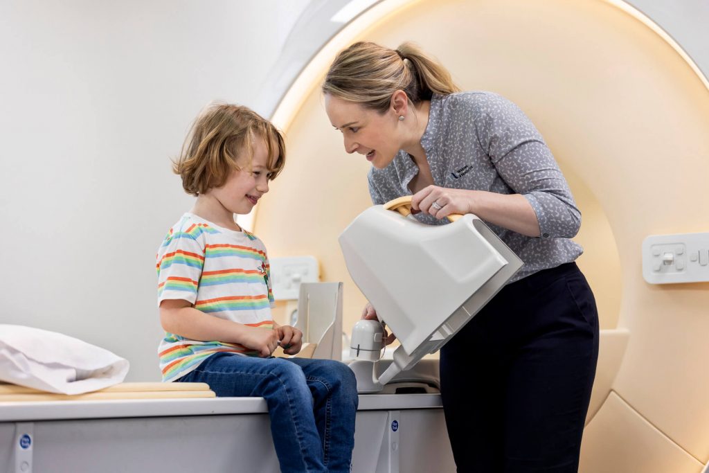 Caring radiographer with a young MRI scan patient at Imaging Associates.